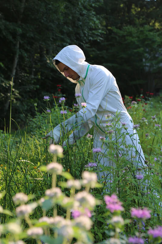 Man in tall grass wearing TheTickSuit